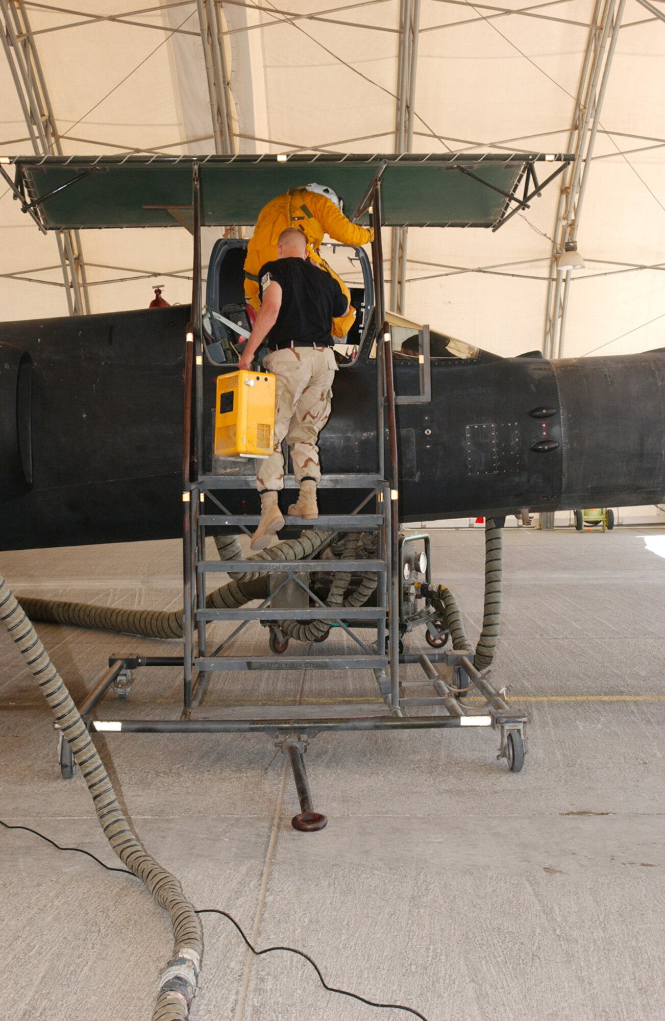 SOUTHWEST ASIA -- Senior Airman Duane Thompson helps Maj. Cory Bartholomew into a U-2 reconnaissance aircraft.  The space suits U-2 pilots wear are bulky and limit movement, so life-support crew specialists strap the pilots into the cockpit and connect hoses and communication systems.  The pilots wear space suits because they typically fly higher than 60,000 feet -- twice as high as a commercial airliner.  Airman Thompson is a life-support crew specialist with the 99th Expeditionary Reconnaissance Squadron's physiological support division.  Major Bartholomew is a U-2 pilot with the 99th ERS.  (U.S. Air Force photo by Staff Sgt. Justin Jacobs)