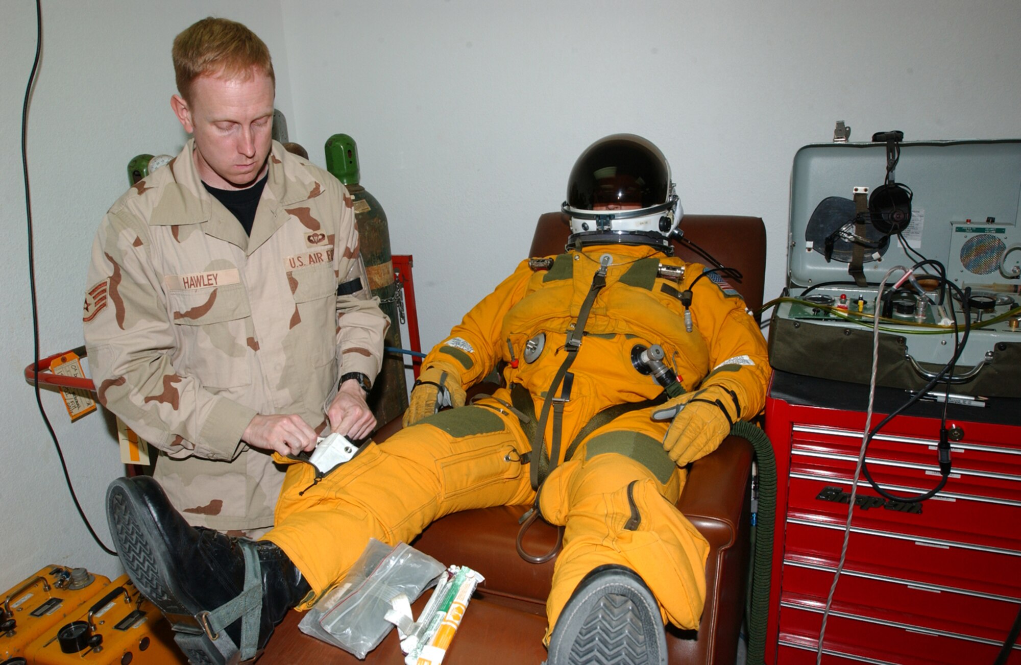 SOUTHWEST ASIA -- Staff Sgt. Craig Hawley prepares Maj. Cory Bartholomew for a U-2 reconnaissance aircraft mission.  U-2 pilots wear space suits because they typically fly higher than 60,000 feet -- twice as high as a commercial airliner.  Sergeant Hawley is the launch and recovery supervisor for the 99th Expeditionary Reconnaissance Squadron's physiological support division.  Major Bartholomew is a U-2 pilot with the 99th ERS.  (U.S. Air Force photo by Staff Sgt. Justin Jacobs)