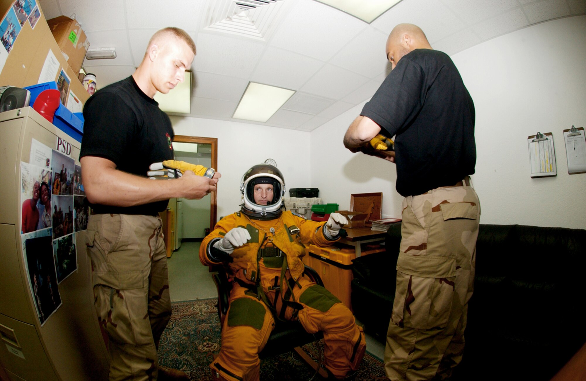 SOUTHWEST ASIA -- Senior Airman Duane Thompson (left) and Staff Sgt. Shann Elmore help Maj. Cory Bartholomew into his space suit before a flight in a U-2 reconnaissance aircraft.  U-2 pilots wear space suits because they typically fly higher than 60,000 feet -- twice as high as a commercial airliner.  Airman Thompson and Sergeant Elmore are life-support crewmembers with the 99th Expeditionary Reconnaissance Squadron's physiological support division.  Major Bartholomew is a U-2 pilot with the 99th ERS.  (U.S. Air Force photo by Staff Sgt. Justin Jacobs)