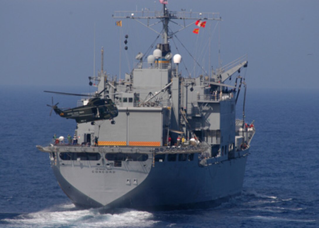 A crewman on the USNS Concord (T-AFS 5) hooks a cargo net of supplies to a UH-3H Sea King helicopter during replenishment at sea operations with the USS Blue Ridge (LCC 19) on March 22, 2005. Concord is one of six combat stores ship operated by the Military Sealift Command to provide supplies, including frozen, chilled and dry provisions and fuel to U.S. Navy combatant ships that are at sea for extended periods of time. 