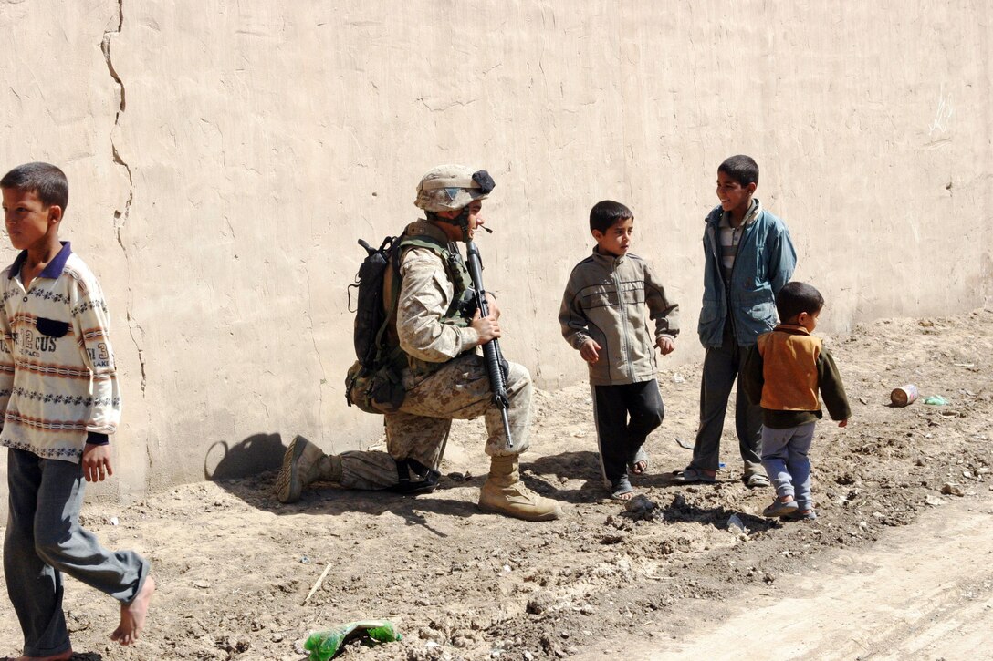 BAGHDAD, Iraq -- (March 24, 2005) - Cpl. Casey J. Leal, 22, an infantry man with A Co., Battalion Landing Team 1/1, and a native of Corpus Christi, Texas, talks to an Iraqi child during a a patrol here. BLT 1/1, attached to the 15th Marine Expeditionary Unit (Special Operations Capable), is currently conducting security and stabilization operations in the Greater Baghdad area. (Official USMC photo by Lance Cpl. Thomas J. Grove)