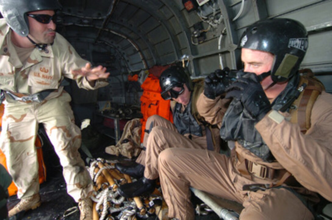 Explosive Ordnance Disposal Senior Technician Chief Petty Officer Robert Snider (left) gives instructions to EOD Technicians Petty Officer 1st Class Jeremy Porter and Petty Officer 2nd Class Justin Harck as they prepare to enter the waters of the Persian Gulf from an H-3 Sea King helicopter during an underwater mine operations phase of Exercise Arabian Gauntlet 2005 on March 23, 2005. Arabian Gauntlet is a multi-lateral surface, air and mine countermeasure exercise designed to practice maritime security operations with coalition partners and allies in the region. 