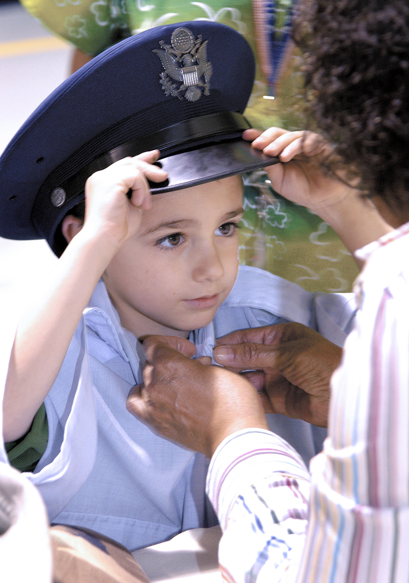 TINKER AIR FORCE BASE, Okla. -- Mason Alexander is swallowed up in Air Force blue at a display where children had their photos taken in grown-up uniforms during a Bring a Child to Tinker event.  The event gave employees a chance to show the children their work world through displays, videos and demonstrations.  (U.S. Air Force photo by Margo Wright)