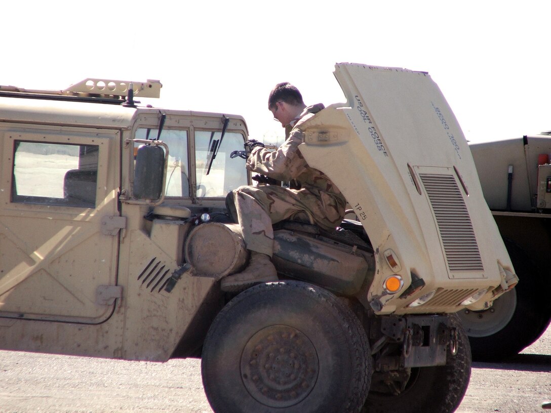 Airman 1st Class William Lawson, does some "on the spot" maintenance with a security forces Humvee during operations here.  Airman Lawson is a vehicle mechanic with the 416th Expeditionary Mission Support Squadron vehicle maintenance flight here.  He is deployed from Grand Forks Air Force Base, N.D.  (U.S. Air Force Photo by Tech. Sgt. Scott T. Sturkol)