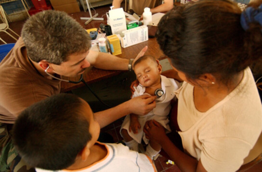 U.S. Navy Cmdr. Ron Hicks uses his stethoscope to listen to the heart of a baby during an examination in Santa Lucia, El Salvador, on March 23, 2005. Hicks is examining El Salvadorans during a medical readiness training exercise. The exercise is part of the Joint Task Force New Horizons Exercise project 'Para los Ninos' which is contributing two new schools and three clinics in areas of San Vicente that were hit by earthquakes. Hicks is deployed from the Operational Support Hospital Unit, Great Lakes, Ill. 