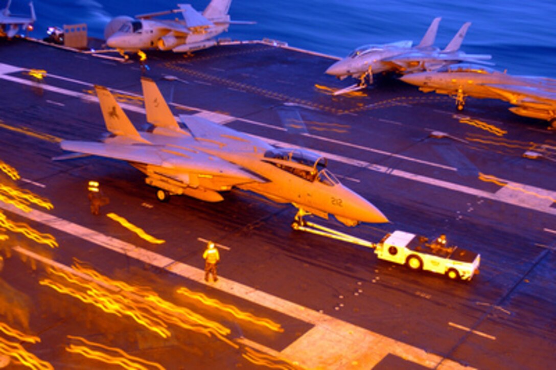 A Navy F-14D Tomcat is towed across the flight deck of the USS Theodore Roosevelt (CVN 71) after a day of flight operations on March 25, 2005. The aircraft carrier and its embarked Carrier Air Wing 8 are training while underway in the Atlantic Ocean. The Tomcat is assigned to Fighter Squadron 213. 