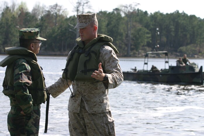 MARINE CORPS BASE CAMP LEJEUNE, N.C. (March 30, 2005) - Second Lt. Jason R. Berner, platoon commander, Improved Ribbon Bridge Platoon, Bridge Company, 8th Engineer Support Battalion, describes the characteristics and capabilities of the Improved Ribbon Bridge to Lt. Col. Yong Il Kim, a Republic of Korea Marine. Kim, a supply officer, and Maj. Ha Seo Park, a logistics officer, visited the base to get a better understanding of what 8th ESB and other 2nd Force Service Support Group Marines do and how they could apply it to their Corps. (Official U.S. Marine Corps photo by Lance Cpl. Bobby J. Segovia)