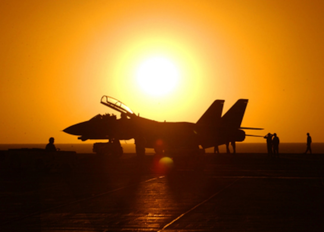 The setting sun silhouettes an F-14D Tomcat of Fighter Attack Squadron 31 after a day of flight operations onboard the USS Theodore Roosevelt (CVN 71) on March 28, 2005. The aircraft carrier and its embarked Carrier Air Wing 8 are training while underway in the Atlantic Ocean. 