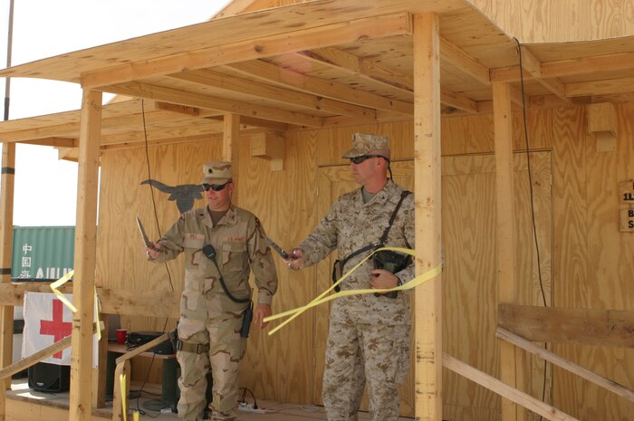 CAMP TAQADDUM, Iraq (May 1, 2005) – Army Lt. Col. Bill A. Hall, battalion commander, 2nd Battalion, 112th Armor, 36th Infantry Division (left), and Marine Col. John E. Wissler, commander of 2d Force Service Support Group (Forward), cut the ribbon signifying the opening of the 2-112th’s new Battalion Aid Station in a ceremony here May 1. The BAS was built by the Soldiers of the 2-112th to better facilitate the medical treatment of their Soldiers and other service members seeking routine care. (Photo by Cpl. John E. Lawson Jr. For more information on this event or the service members, please contact the 2d FSSG (FWD) public affairs office at cssemnfpao@cssemnf-wiraq.usmc.mil)