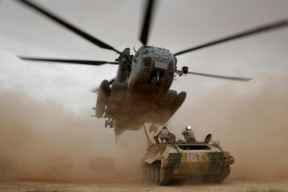 AL ASAD, Iraq ? A CH-53E Super Stallion from Marine Heavy Helicopter Squadron 465 approaches a hulk as Marines from a Combat Logistics Battalion 2 helicopter support team wait to hook the vehicle to the helicopter May 2.  One Super Stallion from HMH-465 moved six hulks of Russian armored vehicles and avoided risking Marines? lives and damages to ground transportation equipment.