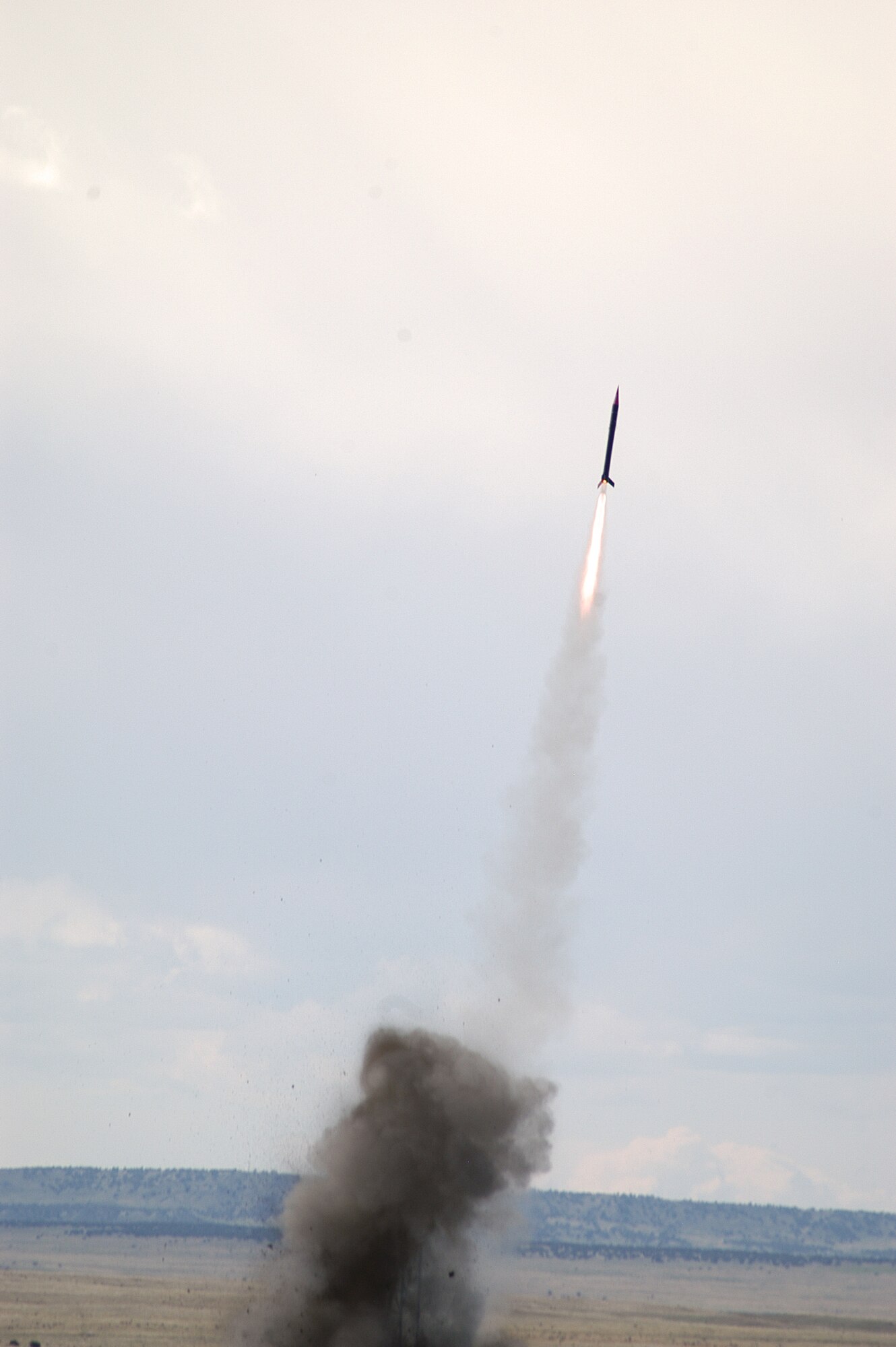 PINON CANYON MANUEVER RANGE, Colo. -- The FalconLaunch rocket lifts off to reach 13,400 feet above the ground in 33 seconds April 30.  During the program, cadets design, manage, build and launch a rocket as part of the Air Force Academy's Department of Astronautics course.  The program progresses each academic year, with the eventual goal of creating a rocket which can deliver a 5-pound scientific or experimental payload to an altitude of about 60 miles.  (U.S. Air Force photo by John Van Winkle)