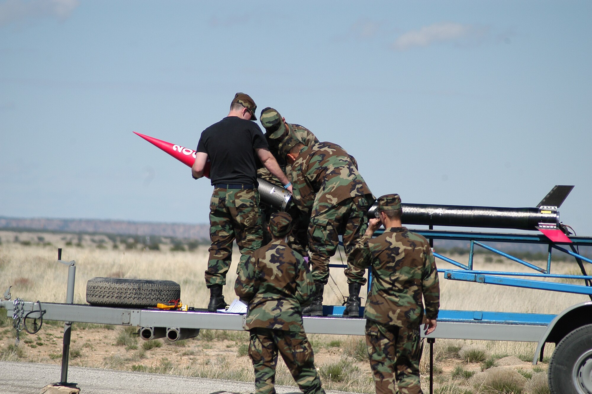 PINON CANYON MANUEVER RANGE, Colo. -- Cadet launch crews attach the FalconLaunch rocket nose cone and avionics package to the rocket body April 30.   During the program, cadets design, manage, build and launch a rocket as part of the Air Force Academy's Department of Astronautics course.  The program progresses each academic year, with the eventual goal of creating a rocket which can deliver a 5-pound scientific or experimental payload to an altitude of about 60 miles.  (U.S. Air Force photo by John Van Winkle)