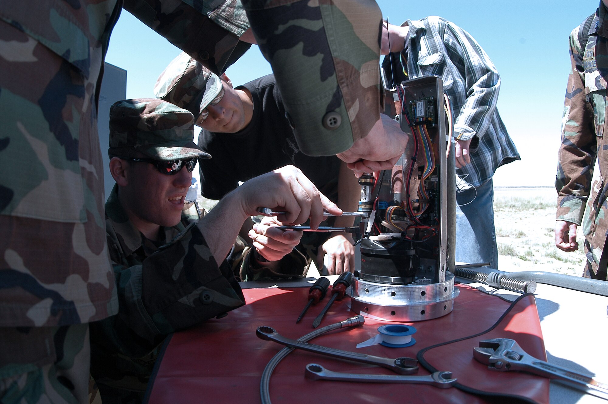 PINON CANYON MANUEVER RANGE, Colo. -- Cadet 1st Class Eric Ray tightens a connection on the FalconLaunch rocket's avionics section, before assembly April 30.  During the program, cadets design, manage, build and launch a rocket as part of the Air Force Academy's Department of Astronautics course.  The program progresses each academic year, with the eventual goal of creating a rocket which can deliver a 5-pound scientific or experimental payload to an altitude of about 60 miles.  (U.S. Air Force photo by John Van Winkle)