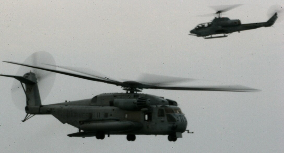An AH-1W Super Cobra escorts a CH-53E Super Stallion during the 2005 McDonald's Air and Sea show. More than 2 million people came out to watch the Marine Air Ground Task Force demonstration.