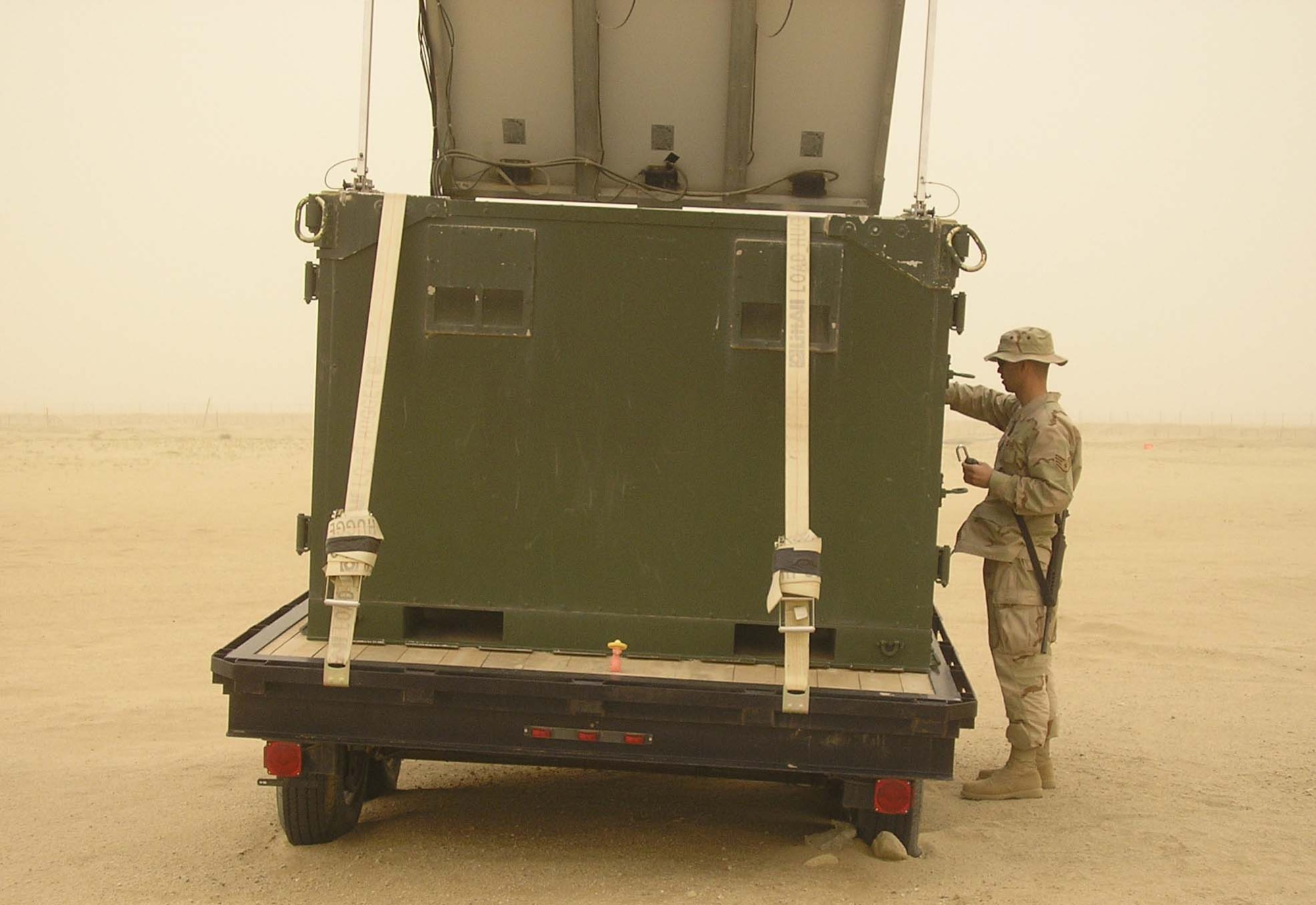 BAGRAM AIR BASE, Afghanistan - Staff Sgt. Cody Williams, 455th Expeditionary Mission Support Squadron Joint Radio Relay team member, repairs a JR2 during a dust storm at a remote site in Afghanistan. The system has similar capabilities to the E-3 Sentry airborne warning and control system.  Sergeant Williams, a ground radio communications craftsman by trade, is deployed from Royal Air Forces Lakenheath, England. (U.S. Air Force photo by Eric Anderson)