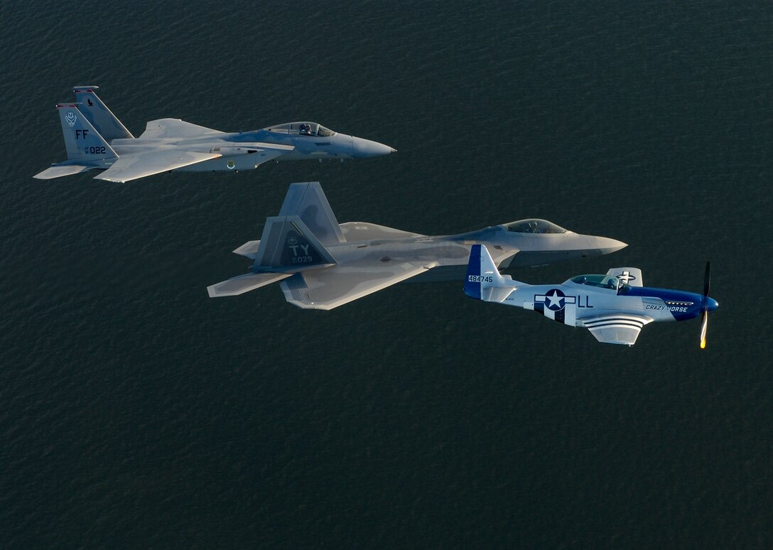 OVER ATLANTIC OCEAN (AFPN) - An F-15 Eagle, F/A-22 Raptor and P-51 Mustang train for heritage flight formation flying April 27 off the coast of Langley Air Force Base, Va.  Maj. Michael Shower, piloting the F/A-22, is getting his checkout ride for the formation with P-51 Pilot Maj. Gen. Mike Decuir, the Air Combat Command operations director, and Capt. Jason Costello, a 1st Fighter Wing demonstration team pilot.  (U.S. Air Force photo by Tech. Sgt. Ben Bloker)
