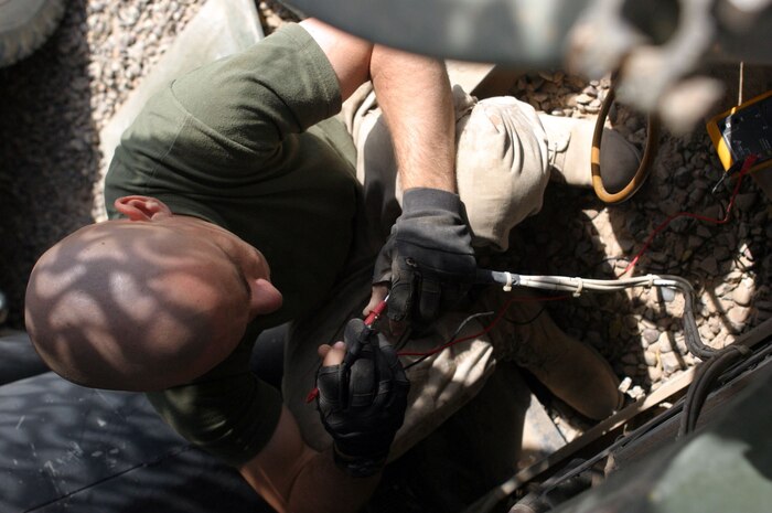 CAMP FALLUJAH, Iraq -- Private first class Richard Harrington, Brooklyn, N.Y., native and refrigeration mechanic, tests an air conditioner unit with a voltage meter to see if there is power.  Harrington, assigned to Utilities repair section of Maintenance Company, Combat Logistics Battalion 8, 2d Force Service Support Group (Forward), said he has always enjoyed working with electrical components.