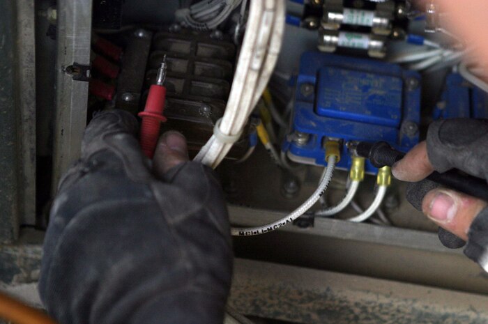 CAMP FALLUJAH, Iraq -- Private first class Richard Harrington, Brooklyn, N.Y., native and refrigeration mechanic, tests an air conditioner unit with a voltage meter to see if there is power.  Harrington, assigned to Utilities repair section of Maintenance Company, Combat Logistics Battalion 8, 2d Force Service Support Group (Forward), said he has always enjoyed working with electrical components.
