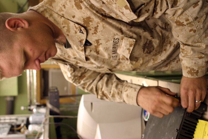 CAMP FALLUJAH, Iraq -- Lance Cpl. Travis Nichelson, a ground radio repair technician with Communications repair section, tries to repair an amplifier unit.  Nichelson, a North Platte, Neb., native, is assigned to Maintenance Company, Combat Logistics Battalion 8, 2d Force Service Support Group (Forward).