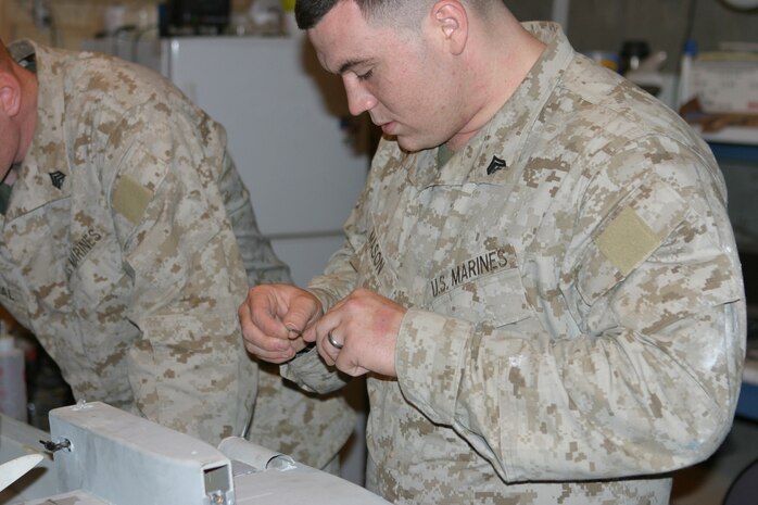 CAMP TAQADDUM, Iraq (May 19, 2005) - Corporal Harley Mason III, a Snowhill, N.C., native, repairs a damaged Dragon Eye unmanned aerial vehicle. Mason is one of three Marines from 4th Echelon Section, Electronics Maintenance Platoon, Maint. Detachment, Combat Logistics Regiment 25, 2d Force Service Support Group (Forward), who are responsible for repairing all the Dragon Eyes for the Marine Corps.