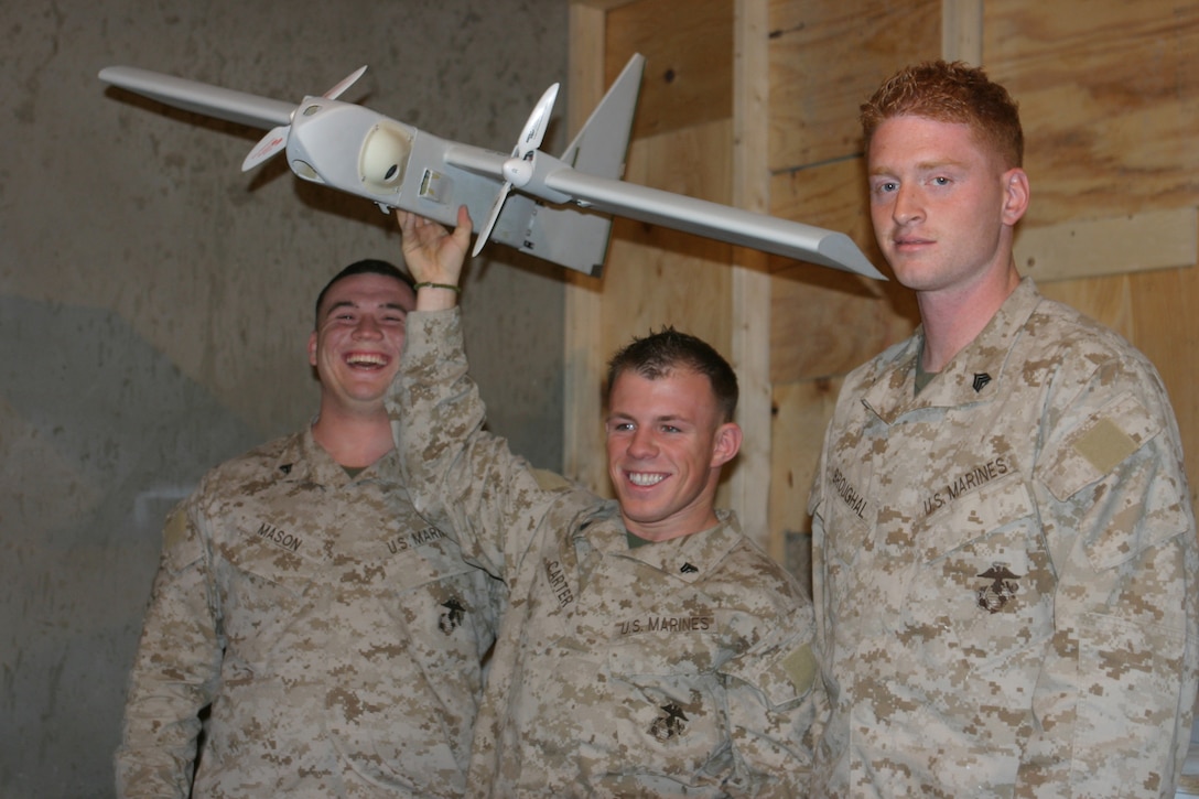 CAMP TAQADDUM, Iraq (May 19, 2005) - Corporal Harley Mason III (left), a Snowhill, N.C., native, Cpl. Jeremy R. Carter, a Northville, Mich., native, and Sgt. Patrick W. Broughal, a Pinebrush, N.Y., native, are the three Marines from 4th Echelon Section, Electronics Maintenance Platoon, Maint. Detachment, Combat Logistics Regiment 25, 2d Force Service Support Group (Forward), who are responsible for repairing all the Dragon Eyes for the Marine Corps.