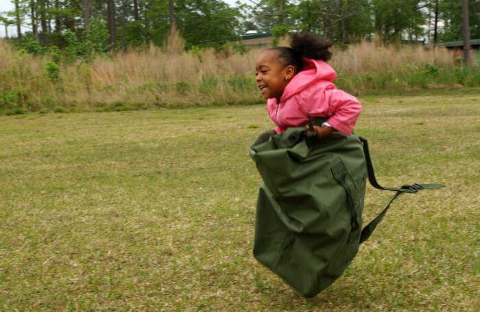 050504-M-1188A-003 CAMP LEJEUNE, N.C. (May 4, 2005) - Tamia Covington, 5, races down the field during the sea bag race here May 4. More than 15 Marines with Headquarters and Service Battalion, 2nd Supply Battalion, 2nd Force Service Support Group, introduced various Marine Corps issued gear to students at the Tarawa Terrace 1 Primary School. (U.S. Marine Corps Photo by Lance Cpl. Joel Abshier)(Released)