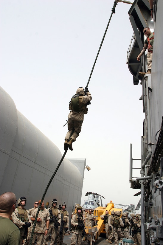 A Marine from 1st Platoon, Fox Company, Battalion Landing Team 2nd Bn., 8th Marines, 26th Marine Expeditionary Unit (Special Operations Capable) slides down a rope suspended nearly 20 feet from the flight deck of the USS Ponce (LPD-15) the morning of May 4.  These Marines spent as much time sharpening their combat skills aboard ship as they support the Global War on Terror.  (USMC Photo by: Sgt. Roman Yurek)  (Released)