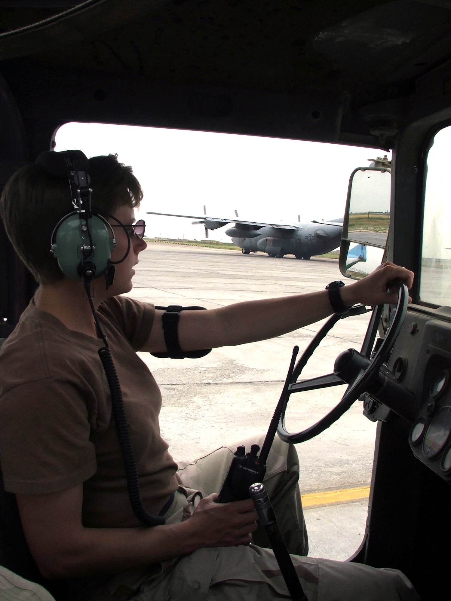 KARSHI-KHANABAD AIR BASE, Uzbekistan -- Tech. Sgt. Emily Green listens to her radio while watching a C-130 Hercules leave on an Operation Enduring Freedom mission from here May 2.  She is the noncommissioned officer in charge of the 416th Air Expeditionary Group's transient alert flight and is deployed from McChord Air Force Base, Wash.  (U.S. Air Force photo by Tech. Sgt. Scott T. Sturkol) 
