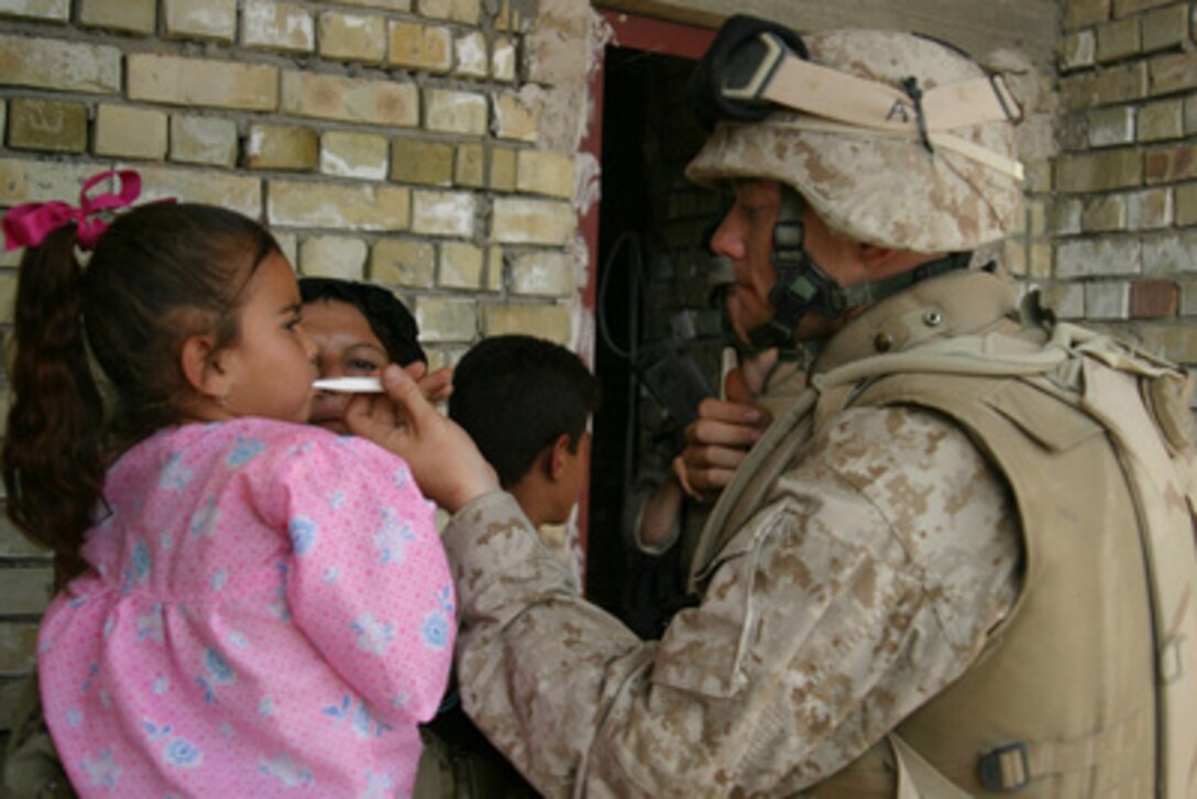 Navy Hospitalman Kevin Crim uses a thermometer to check the temperature of a sick Iraqi child in Kharma, Iraq, on May 1, 2005. Crim is attached to the 4th Platoon, Lima Company, Third Battalion, 8th Marines, 2nd Marine Division, which is in the Al Anbar Province of Iraq to conduct security and stabilization operations in support of Operation Iraqi Freedom. 