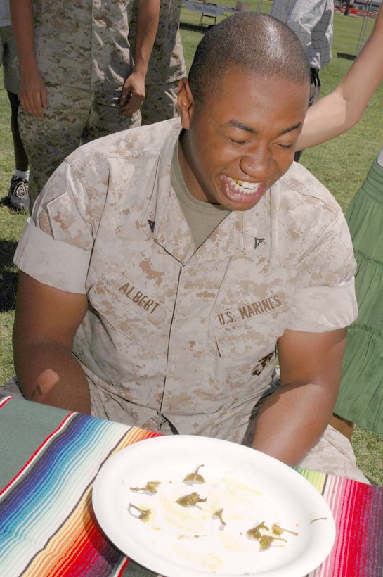 Lance Cpl. Cort Albert, Marine Attack Squadron-211 aviation operations, laughs off the heat after winning the jalapeno eating contest at the biannual Health and Wellness Fair on the station parade deck May 5. The fair aimed to teach Marines about healthy living and the health services available to them on station.