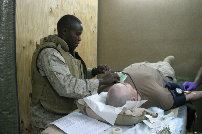 CAMP TAQADDUM, Iraq - Petty Officer 2nd Class Isaac Nyangena, a 31 year-old native of El Doret, Kenya, comforts a Soldier who's giving blood at the Surgical Shock Trauma Platoon March 3 here. A walking blood bank was called into action for a Soldier who was seriously injured by an improvised explosive device that night.