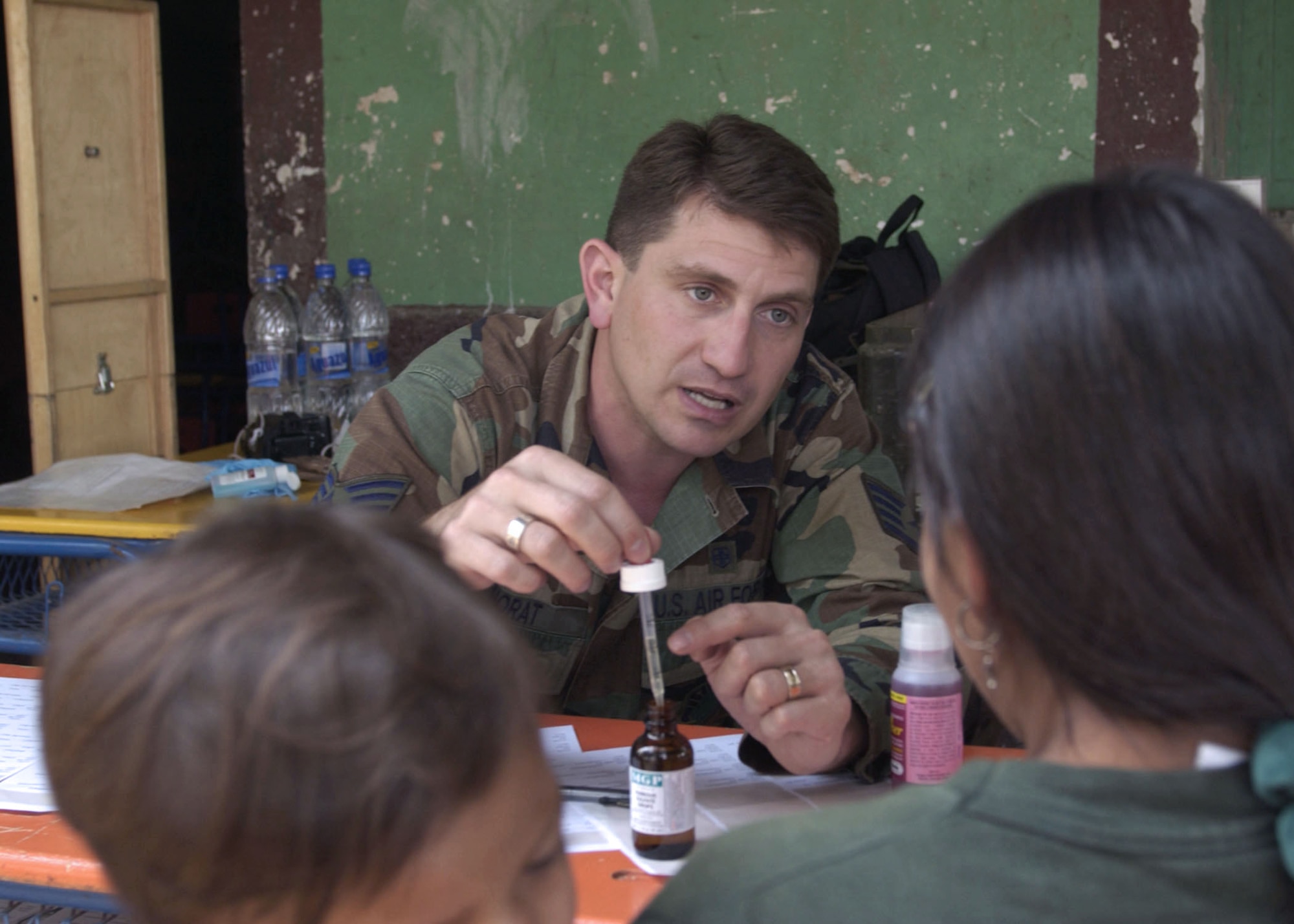 RAUTECA, Honduras -- Staff Sgt. Sergio Norat instructs patients how to use an eyedropper to administer a dose of antibiotic.  An 18-person Air Force and Army contingent of pediatricians, dieticians and medical technicians came from the San Antonio area for an eight-day medical readiness exercise to provide humanitarian relief.  Sergeant Norat is a medical technician and international health specialist from Wilford Hall Medical Center at Lackland Air Force Base, Texas.  (U.S. Air Force photo by Master Sgt. Lono Kollars)