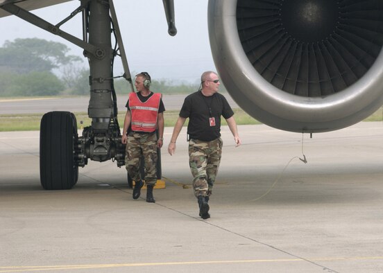 SOTO CANO AIR BASE, Honduras -- Staff Sgt. Karal Schofield (left) and Tech Sgt. Michael McCarthy, transient alert technicians, check a KC-10 Extender from Charleston Air Force Base, S.C.  The huge tanker flies the weekly flight from Charleston, which brings in new Airmen here.  (U.S. Air Force photo by Master Sgt. Lono Kollars)