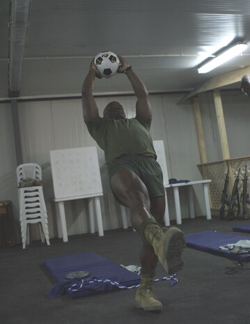 CAMP FALLUJAH, Iraq -- Lance Cpl. Robert Walker, an administrative clerk with Headquarters Company, Combat Logistics Battalion 8, 2d Force Service Support Group (Forward), works out at the "Killer Abs" class taught at the Morale, Welfare and Recreation center here.  The 32-year-old native of Peoria, Ill., was a cheerleader in college and said he wants to stay in the best possible shape.