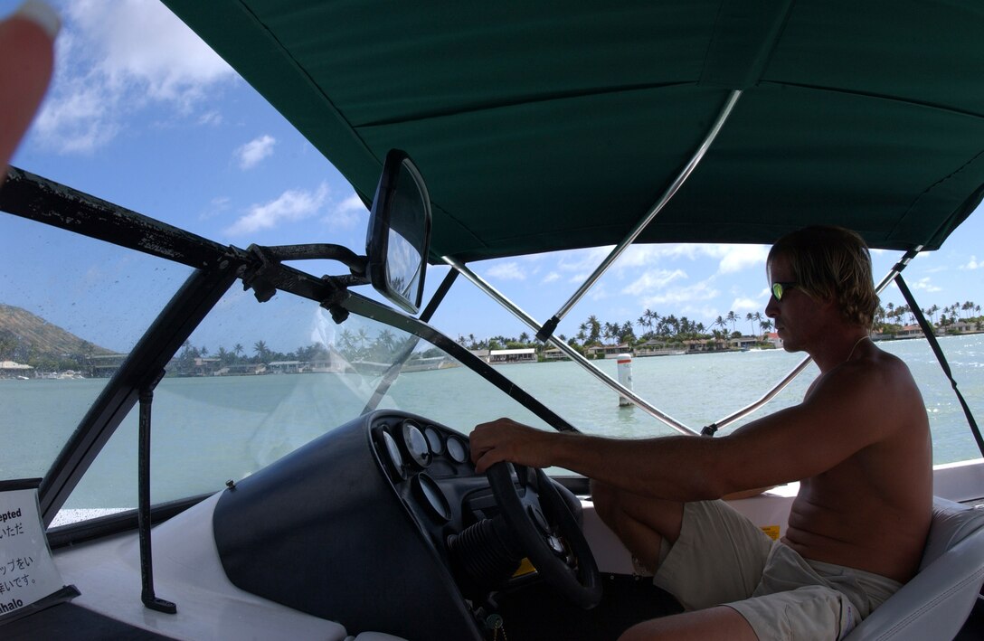 Boat Captain Robert Pacini, a Hawaii Kai resident, cruises around Koko Marina while fellow boat captain Andrew Birch tows a wakeboarder through the calm waters.  Hawaii Water Sports in the Koko Marina Shopping Center offers a wide variety of water activities such as: water skiing, banana boat rides, snorkelng and newly added surfing.