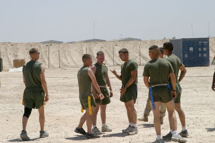 CAMP FALLUJAH, Iraq -- Playing flag foot ball as part of Maintenance Company's fun day is Sgt. Robert Topper, Engineer Maintenance Platoon, platoon sergeant.  The Atlanta native tells another Marine that his team is kicking off after losing in a paper-rock-scissors battle instead of a coin toss.  Maintenance Company is part of Combat Logistics Battalion 8, 2d Force Service Support Group (Forward).