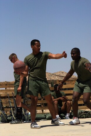 CAMP FALLUJAH, Iraq -- Corporal Harrison Sitorus, a telephone, switchboard and personal computer repairman from Brooklyn, N.Y. tells another Marine to move back to the ball as Lance Cpl. James Simmons, a Philadelphia native and electric repair technician, guards him.  The Marines of Maintenance Company, Combat Logistics Battalion 8, 2d Force Service Support Group (Forward), had a unit fun day for the Marines to "reset" the unit, giving them a break from the normal workday.