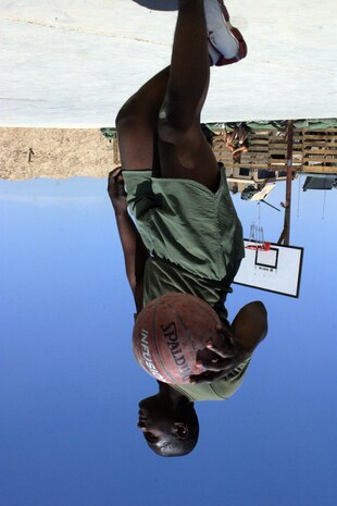 CAMP FALLUJAH, Iraq -- Lance Cpl. James Simmons, a Philadelphia native and electric repair technician, dribbles the basketball up the court during a game.  The Marines of Maintenance Company, Combat Logistics Battalion 8, 2d Force Service Support Group (Forward), had a unit fun day for the Marines to "reset" the unit, giving them a break from the normal workday.