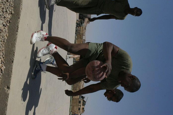 CAMP FALLUJAH, Iraq -- Lance Cpl. James Simmons, a Philadelphia native and electric repair technician, dribbles around another Marine.  The Marines of Maintenance Company, Combat Logistics Battalion 8, 2d Force Service Support Group (Forward), had a unit fun day for the Marines to "reset" the unit, giving them a break from the normal workday.