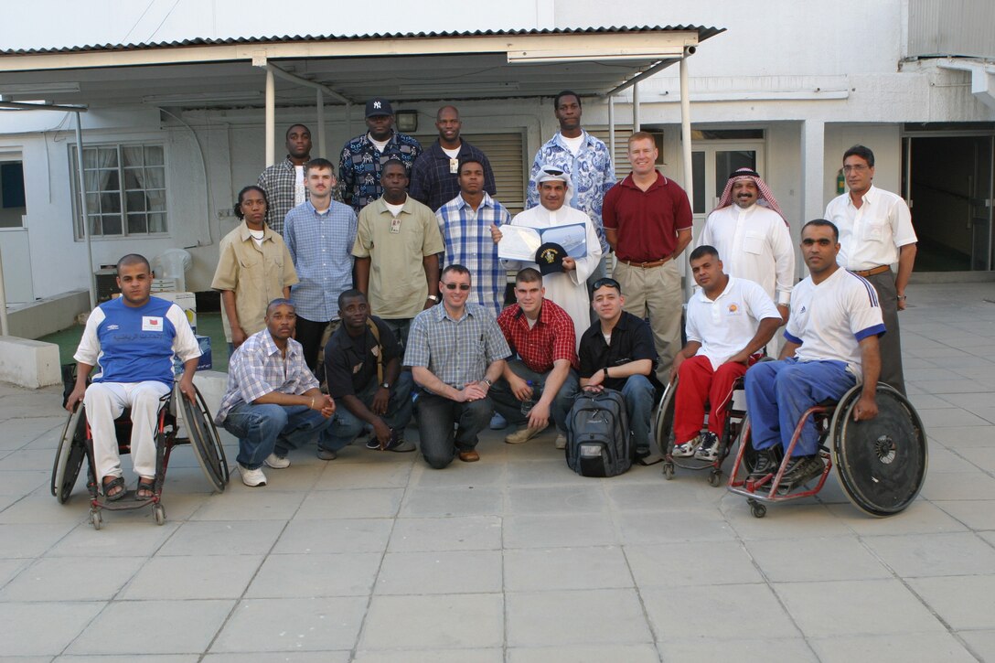 Members of the Bahrain Disabled Sports Foundation and Marines and Sailors of the 26th MEU (SOC) and USS Kearsarge pose for a photo prior to the game.