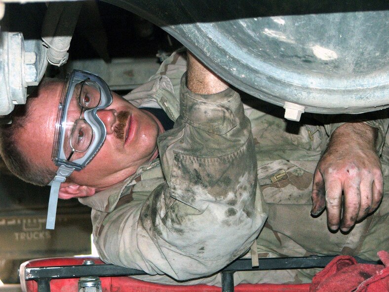 KARSHI-KHANABAD AIR BASE, Uzbekistan -- Staff Sgt. Brian Carter works underneath a fuel truck while doing vehicle maintenance here May 7.  He is a mechanic with the 416th Expeditionary Mission Support Squadron's vehicle maintenance flight and is deployed from Grand Forks Air Force Base, N.D.  (U.S. Air Force photo by Tech. Sgt. Scott T. Sturkol)