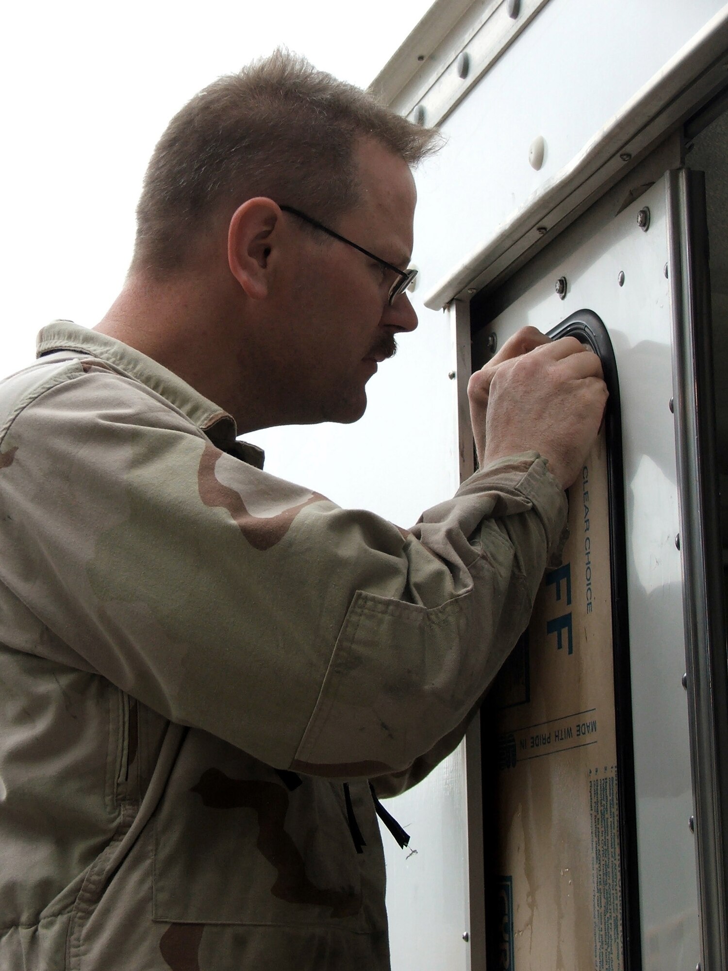 KARSHI-KHANABAD AIR BASE, Uzbekistan -- Tech. Sgt. Scott Rauscher replaces a window in a maintenance van here May 7.  He is a mechanic with the 416th Expeditionary Mission Support Squadron's vehicle maintenance flight and is deployed from Fairchild Air Force Base, Wash.  (U.S. Air Force photo by Tech. Sgt. Scott T. Sturkol)