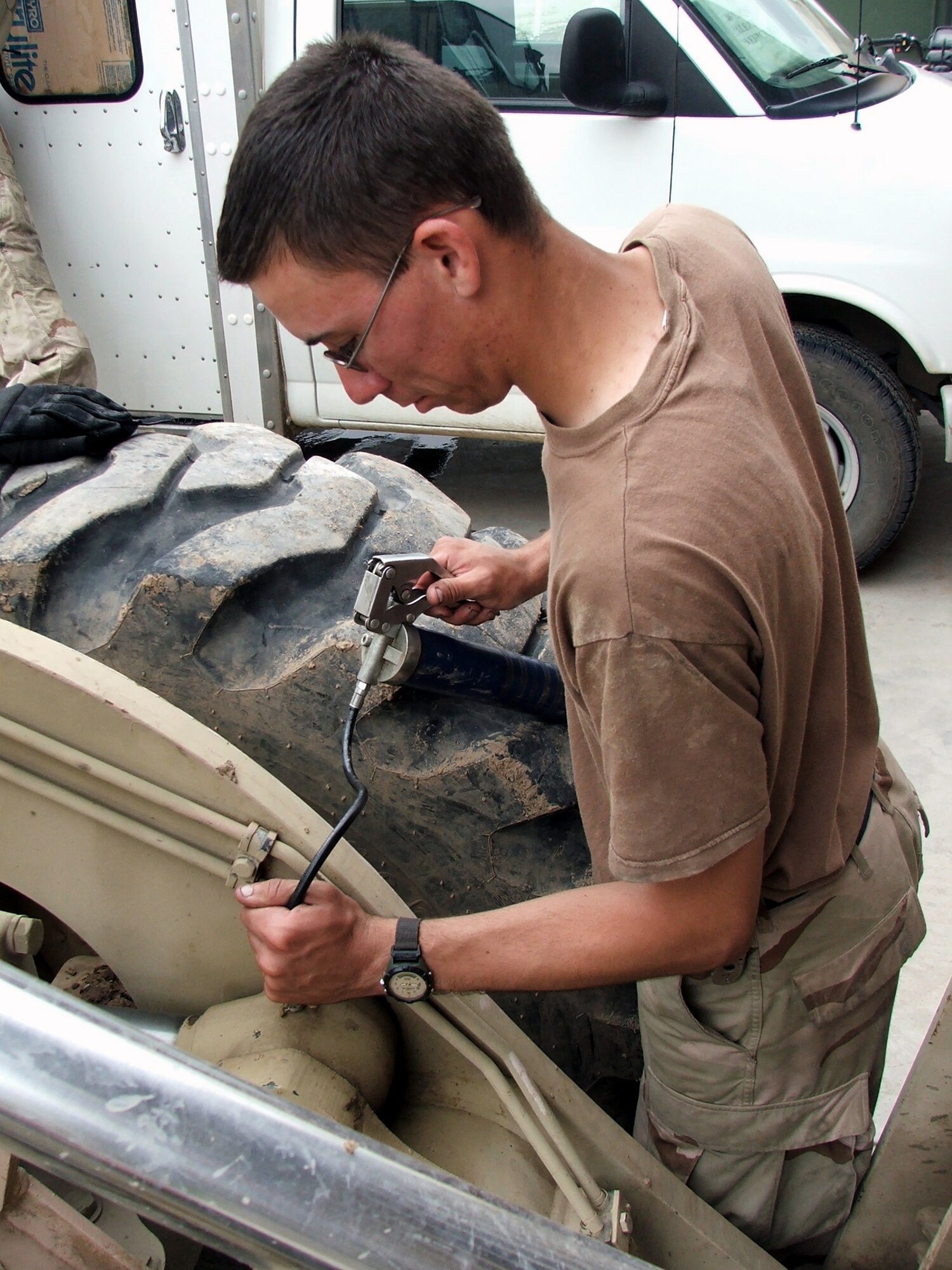 KARSHI-KHANABAD AIR BASE, Uzbekistan -- Airman 1st Class William Lawson uses a grease gun on a forklift in the vehicle maintenance shop here May 7.  He is assigned to the 416th Expeditionary Mission Support Squadron's vehicle maintenance flight and is deployed from Grand Forks Air Force Base, N.D.  (U.S. Air Force photo by Tech. Sgt. Scott T. Sturkol)