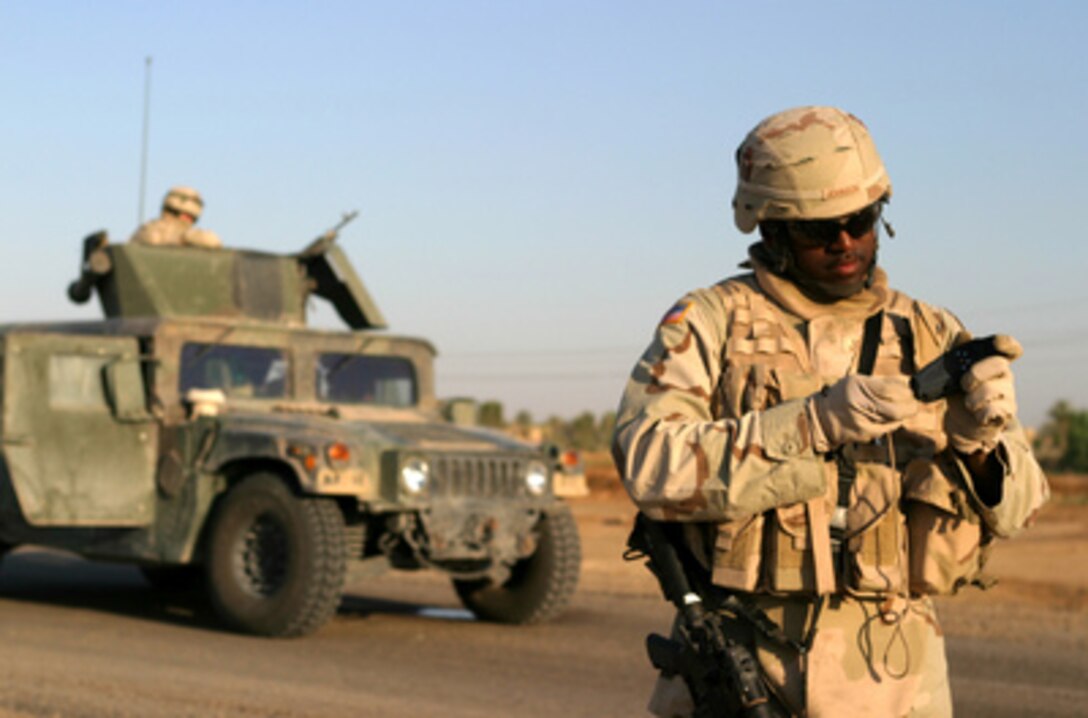 U.S. Army Staff Sgt. Lorenzo Johnson examines his Global Positioning System receiver during a route reconnaissance patrol of Alternate Supply Route Boston in Iraq, on May 6, 2005. Soldiers of Bravo Company, 2nd Battalion, 112th Armor, 56th Brigade Combat Team, 36th Infantry Division, are patrolling Route Boston and Main Supply Route Michigan to inspect any potholes or suspicious landmarks where improvised explosive devices could be concealed. 