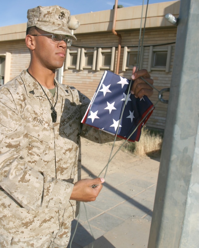 May 10, 2005 Corporal Eric Kyne, a saxophone player with the 2D Marine Aircraft Wing Band, raises morning colors over Al Asad, Iraq. Flag detail is one of the many extra duties the band performs while forward deployed. (USMC photo by Cpl. Alicia M. Garcia)