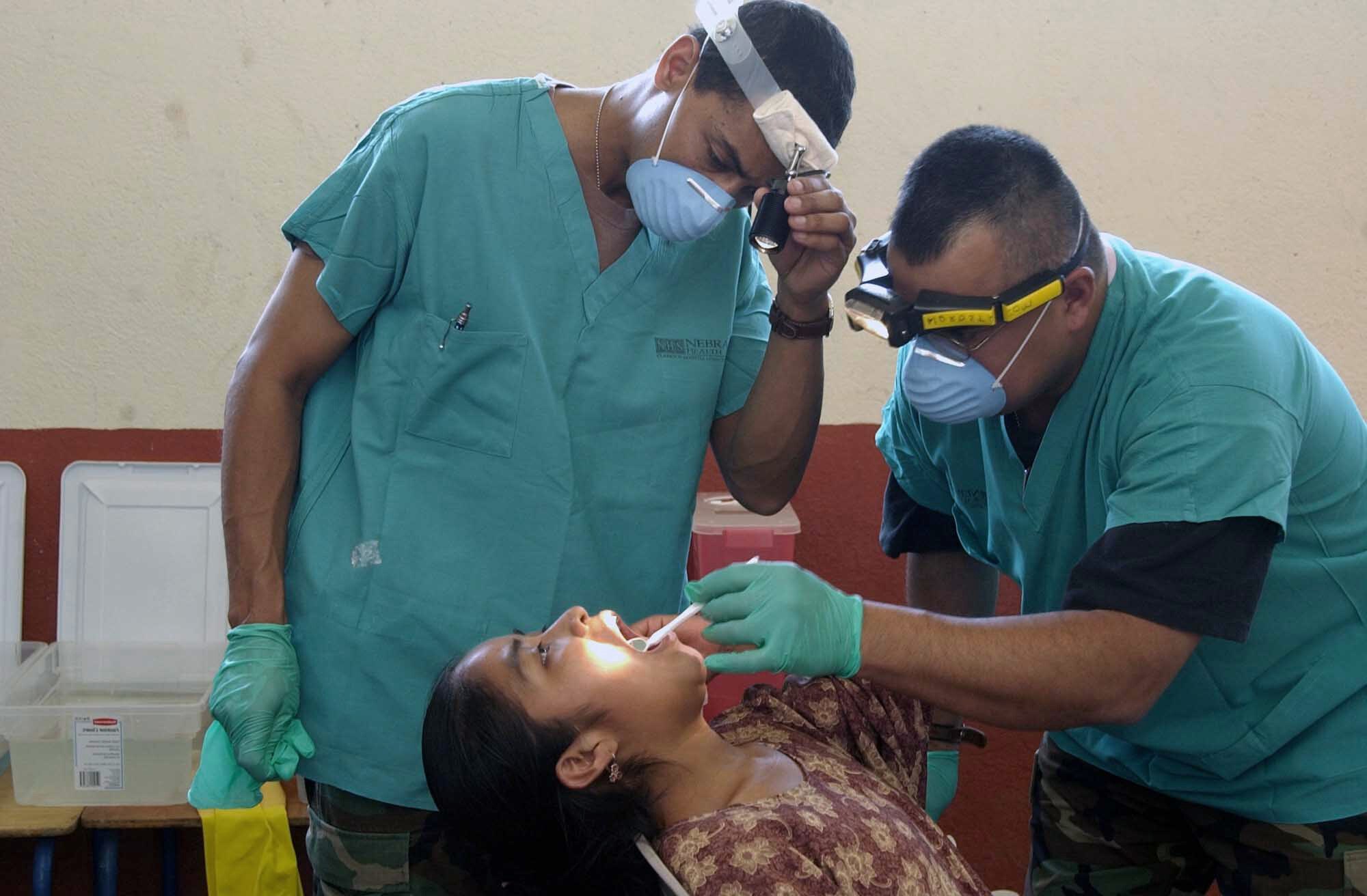 GUATEMALA -- Lt. Col. (Dr.) Gene Gaspard (left) and Tech. Sgt. Ray Salazar give a dental examine to a Guatemalan girl.  Airmen from the Air Force Reserve Command medical community deployed here for a medical readiness training exercise.  During the 10-day deployment, the medical teams treated nearly 1,000 people a day.  Sergeant Salazar and Dr. Gaspard are assigned to the 710th Medical Squadron at Offutt Air Force Base, Neb.  (U.S. Air Force photo by Master Sgt. Ruby Zarzyczny)