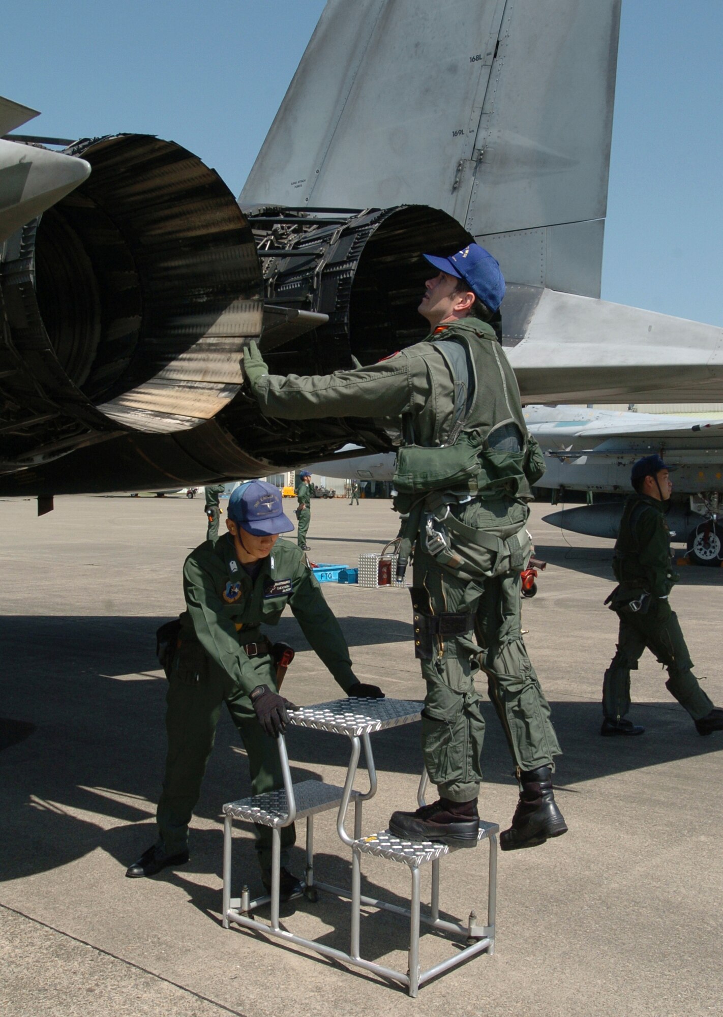 NYUTABARU AIR BASE, Japan -- Capt. Justin Fletcher (right) inspects his F-15 Eagle with Japanese Staff Sgt. Daigo Takayama before a mission.  Captain Fletcher provides F-15 pilot techniques and counterair tactics to Japanese airmen here.  He is a pilot and exchange officer assigned to the 23rd Fighter Tactical Squadron.  (U.S. Air Force photo by Master Sgt. Val Gempis)