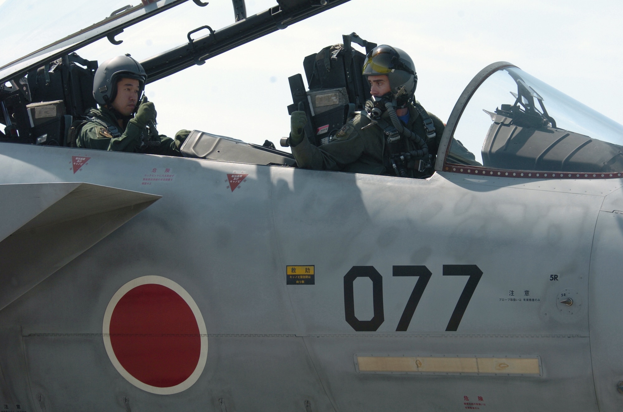 NYUTABARU AIR BASE, Japan -- Capt. Justin Fletcher (right) gives the thumbs up signal to Japanese Capt. Kenechi Ohshima before taking off for a mission.  Captain Fletcher provides F-15 Eagle pilot techniques and counterair tactics to Japanese airmen here.  He is a pilot and exchange officer assigned to the 23rd Fighter Tactical Squadron.  (U.S. Air Force photo by Master Sgt. Val Gempis)