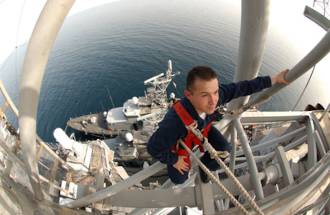 Navy Petty Officer 2nd Class Ryan A. Legge checks radar assemblies for corrosion high on the mast of the guided missile cruiser USS Normandy (CG 60) as the USS Firebolt (PC 10) and USS Typhoon (PC 5) conduct refueling operations alongside on May 8, 2005. The USS Normandy, USS Typhoon and USS Firebolt are conducting maritime security operations setting the conditions for security and stability in the maritime environment. Legge is a Navy electronics technician. 