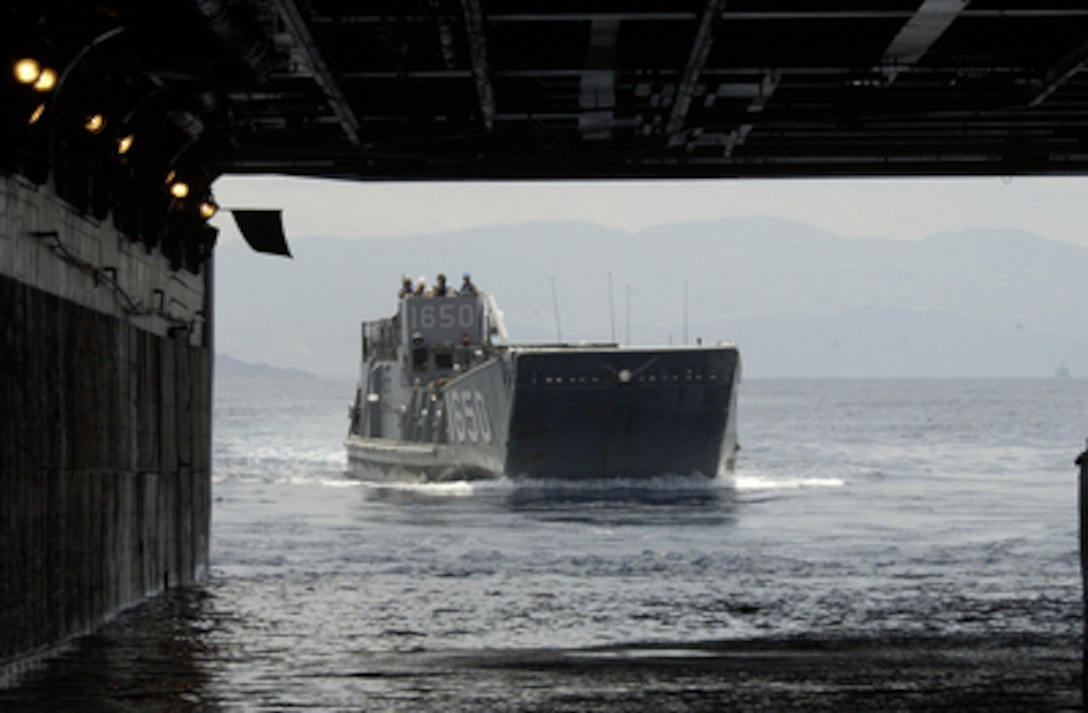 A landing craft utility boat approaches the well deck of the USS Nassau ...